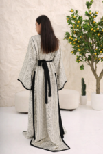 ⁦قفطان فاخر بلون أبيض عاجي مع تفاصيل سوداء بتصميم راقٍ بقطعتين⁩ - الصورة ⁦6⁩