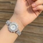 ساعة نسائية فضية فاخرة بتصميم زهرة مرصعة بالكريستال